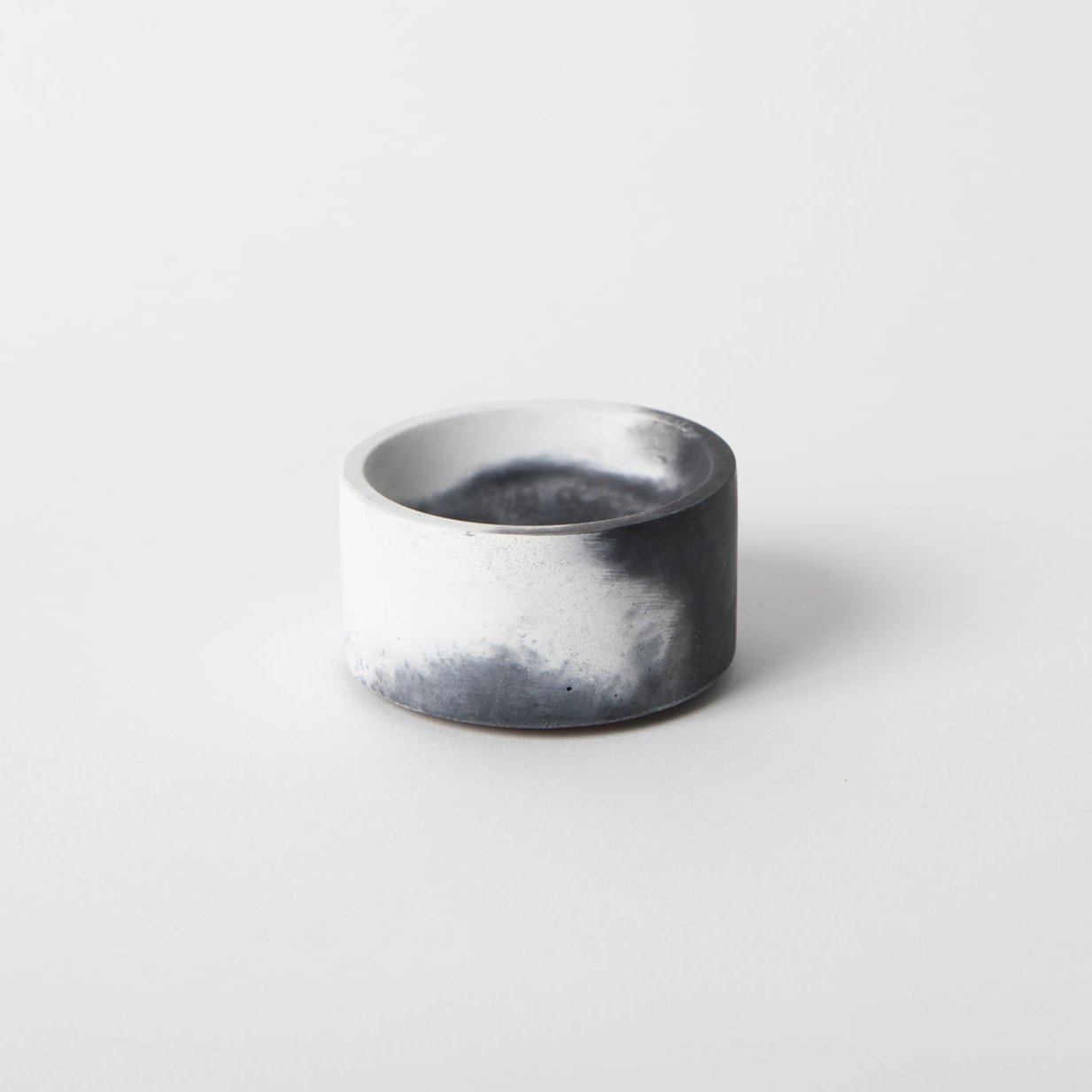 Round concrete incense holder in black and white.