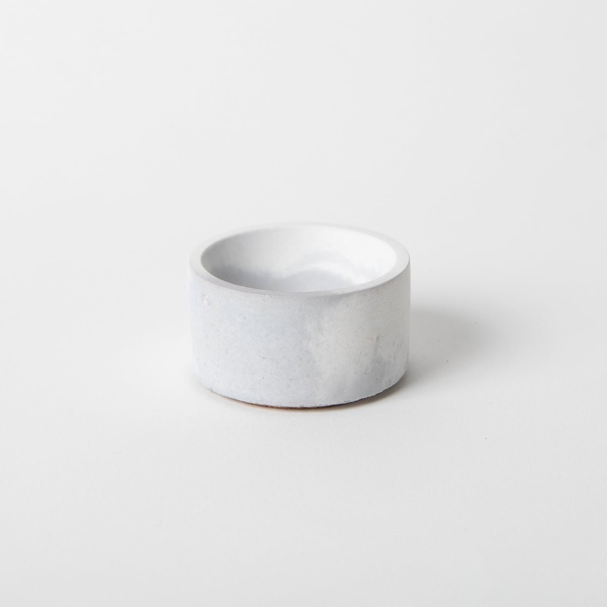 Round concrete incense holder in grey and white.