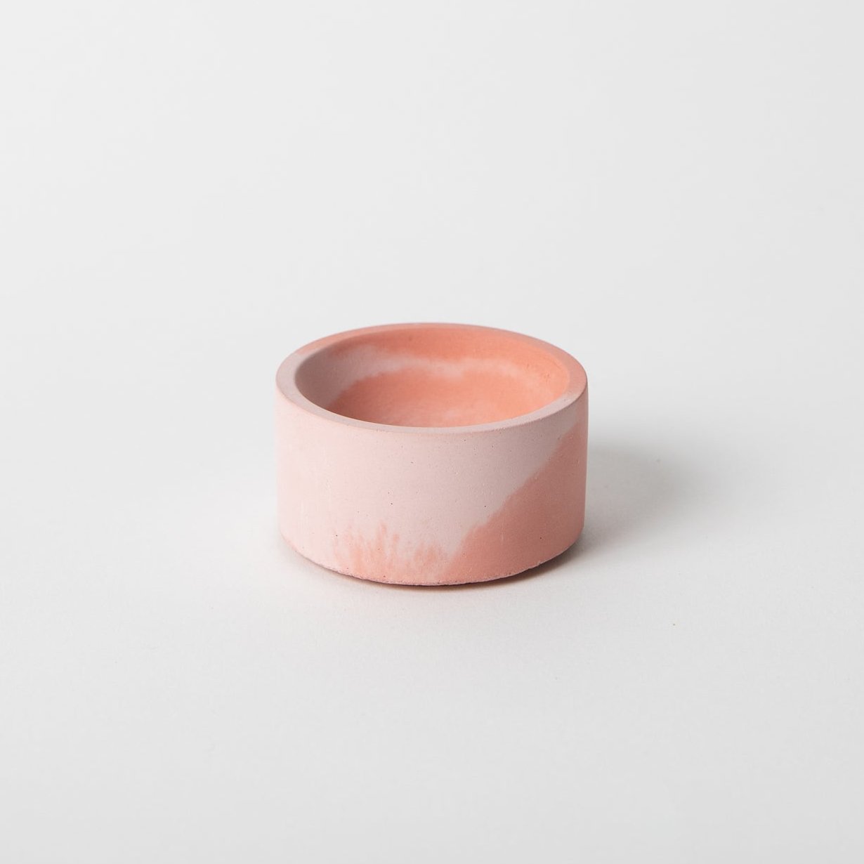 Round concrete incense holder in pink and coral.