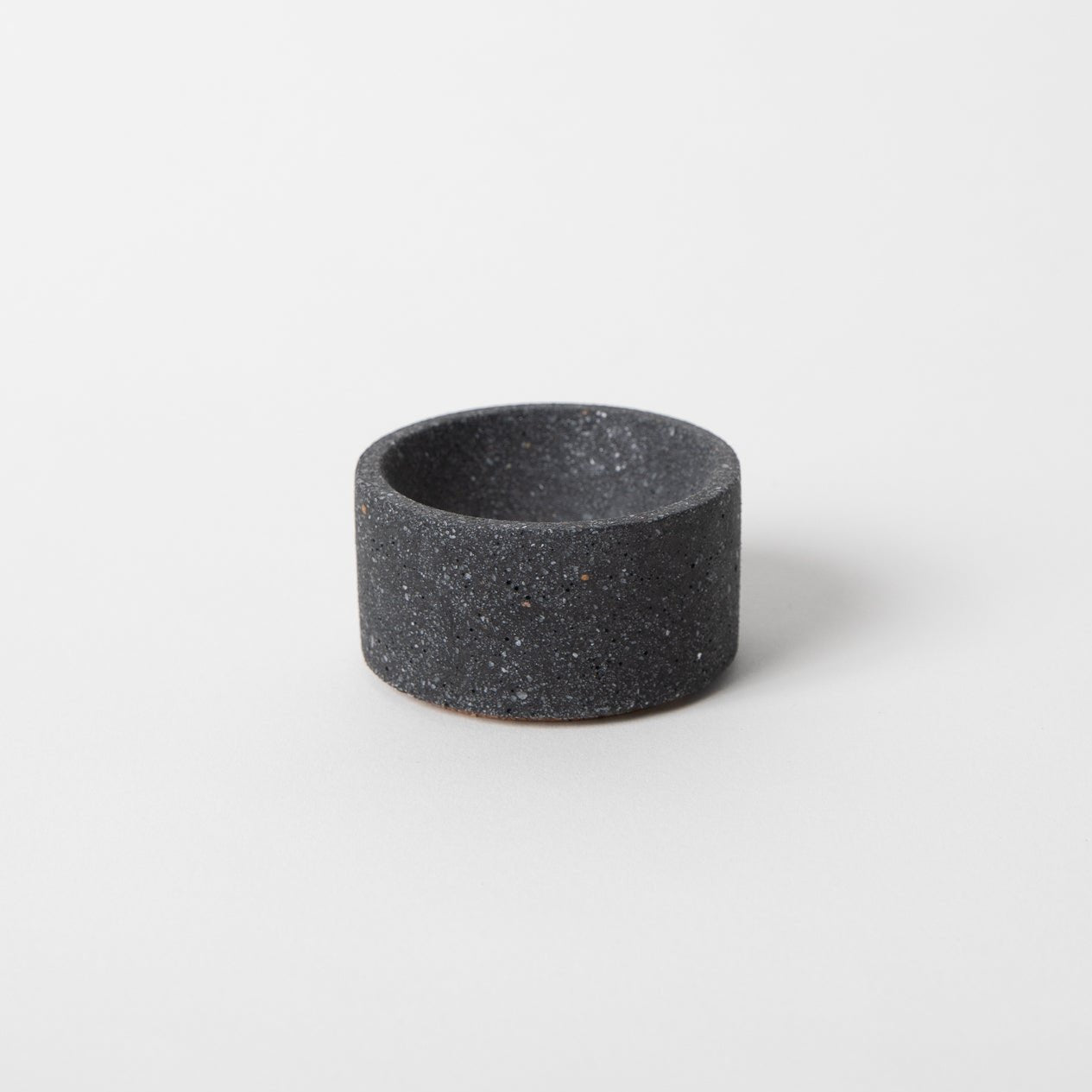 Round terrazzo concrete incense holder in black.