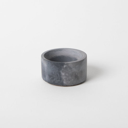 Round concrete incense holder in black and grey.