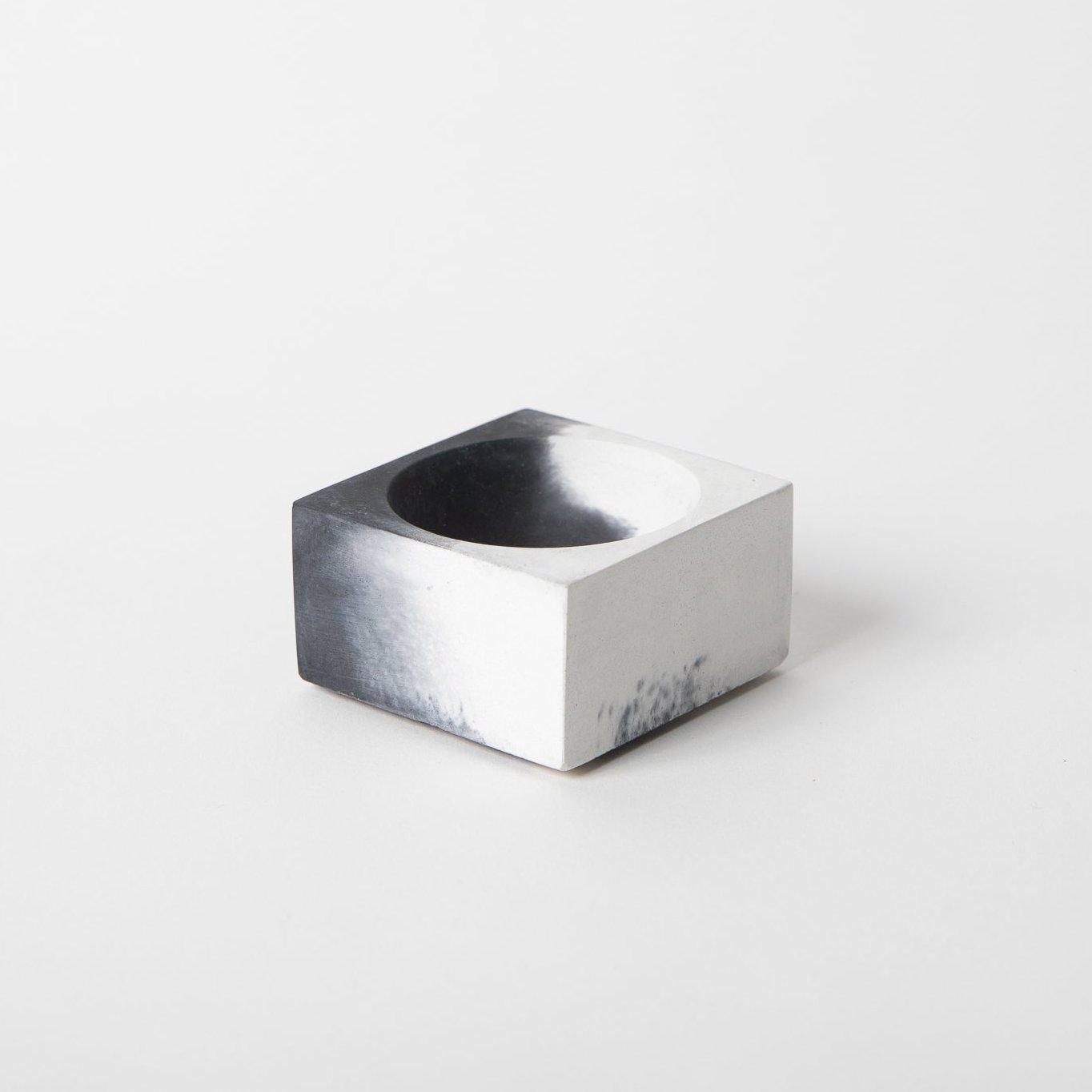 Square concrete incense holder in black and white.
