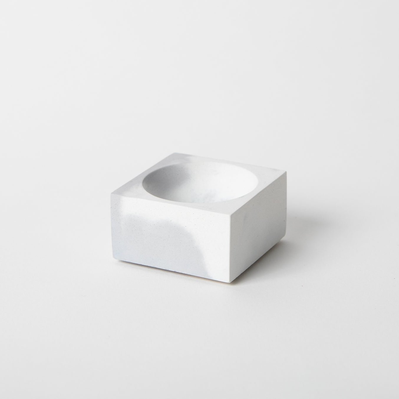 Square concrete incense holder in grey and white.