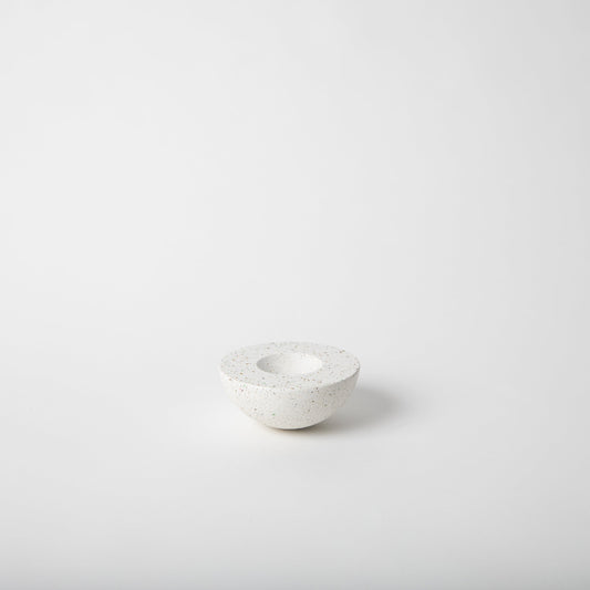 Half sphere shaped incense holder in white terrazzo.